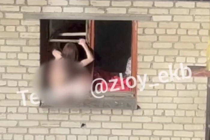 Голая буйная женщина сидит в окошке многоквартирного дома в Екатеринбурге