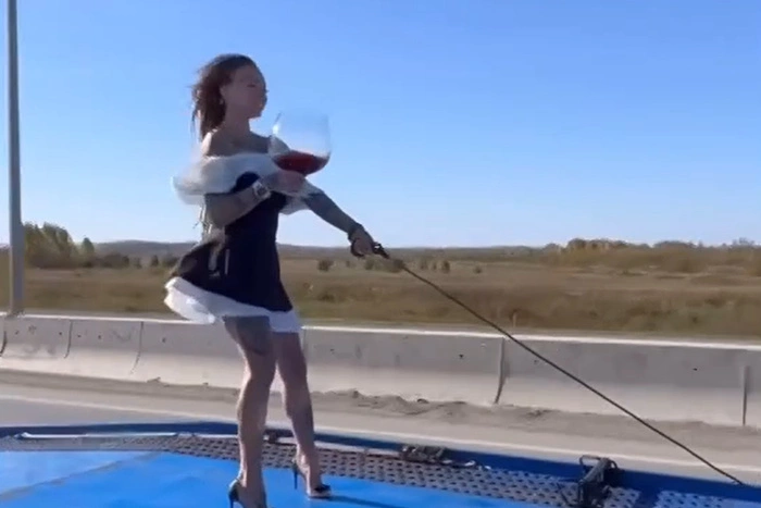 Блогерша прокатилась по ЕКАД, стоя на эвакуаторе с бокалом вина в руках