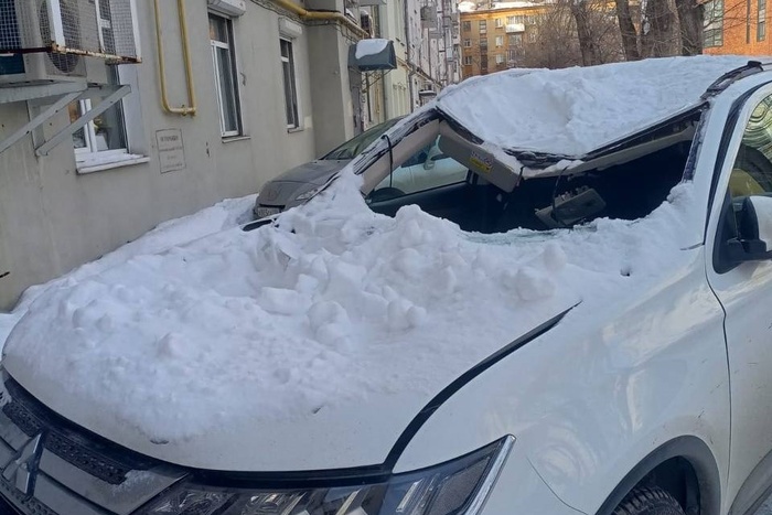 В екатеринбургском дворе снег сошёл на припаркованный автомобиль