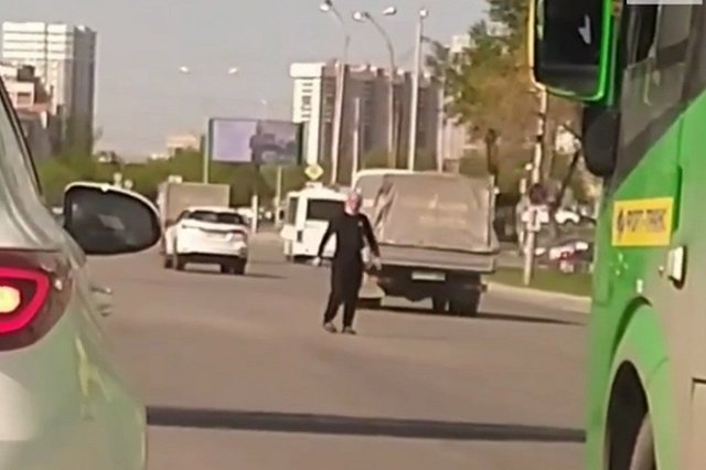 В Екатеринбурге мужчина вышел на дорогу и пытается регулировать движение