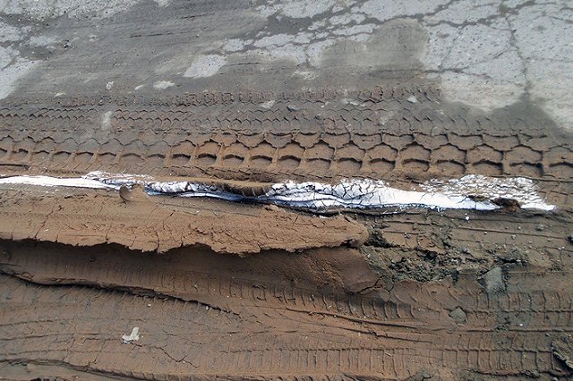 На Вторчермете дорожники нанесли разметку на вздыбленный асфальт и глину