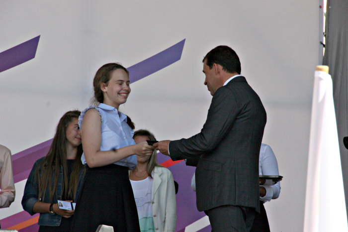 Евгений Куйвашев вручает медалистам студенческие билеты.