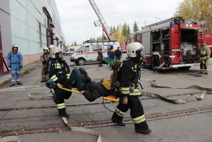 Пожарные эвакуируют работников из цеха