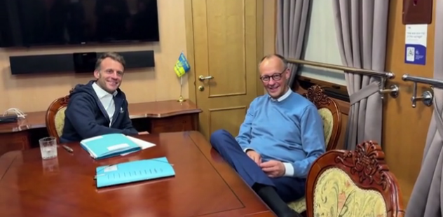 Макрон и Мерц непринужденно позируют после того, как почистили рабочий стол. Фото: скрин видео c сайта The Daily Mail